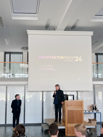 Wolfgang Sitka bei der Begrüßung und Eröffnung der Ausstellung "Architekturpreis Land Salzburg 2024" in der Aula der HLT Saalfelden.
